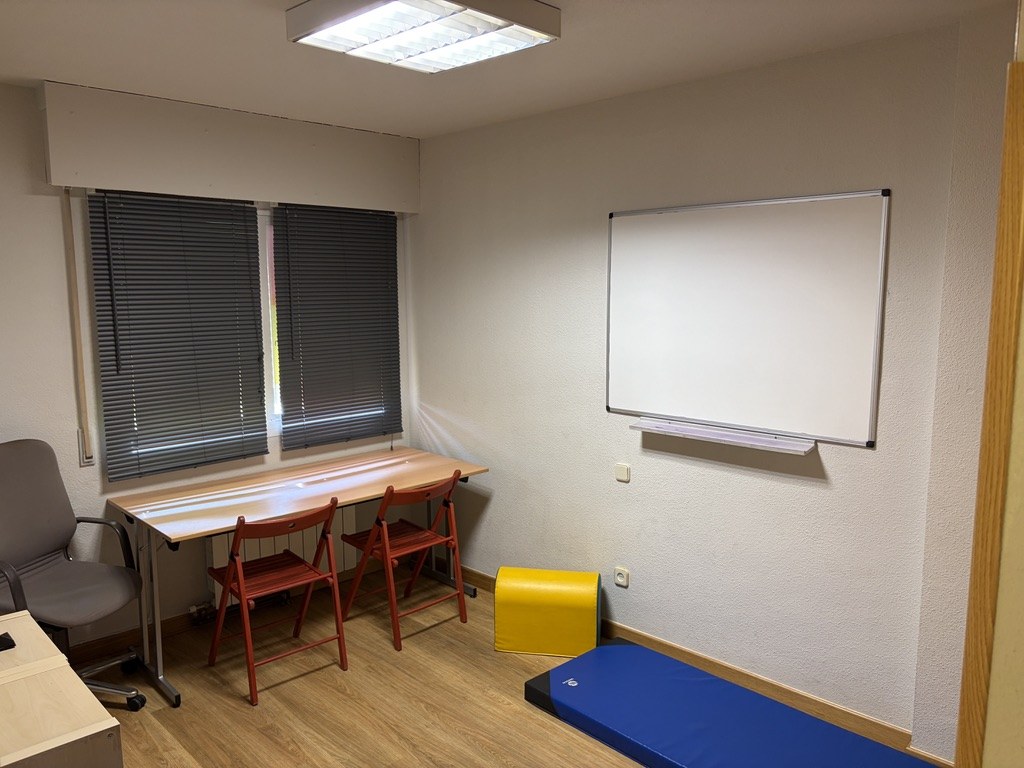 Aula de Cum Laudem con mesa y sillas rojas